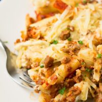 close up of vegan baked ziti on plate with a fork