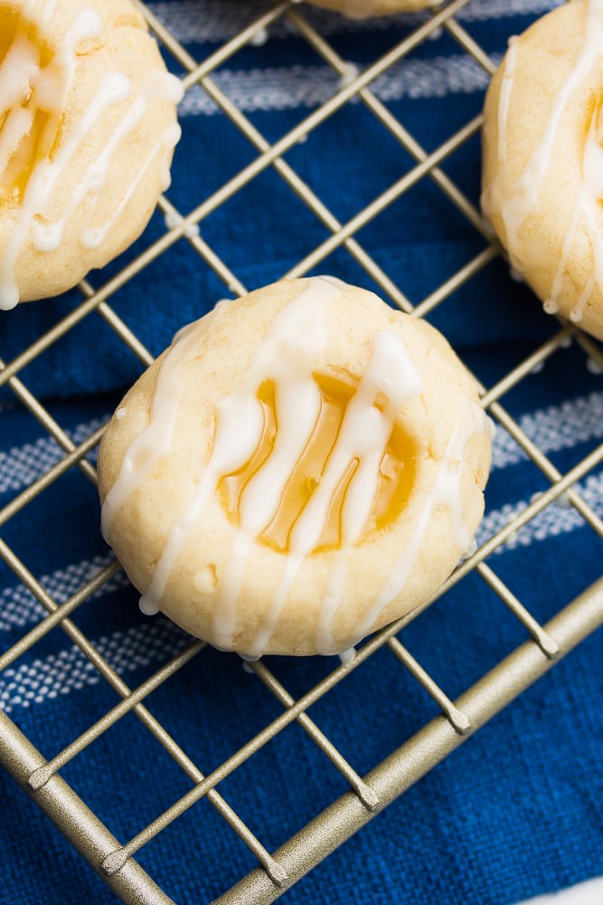 a close up of one vegan lemon shortbread cookie on a cooling rack with a blue towel underneath