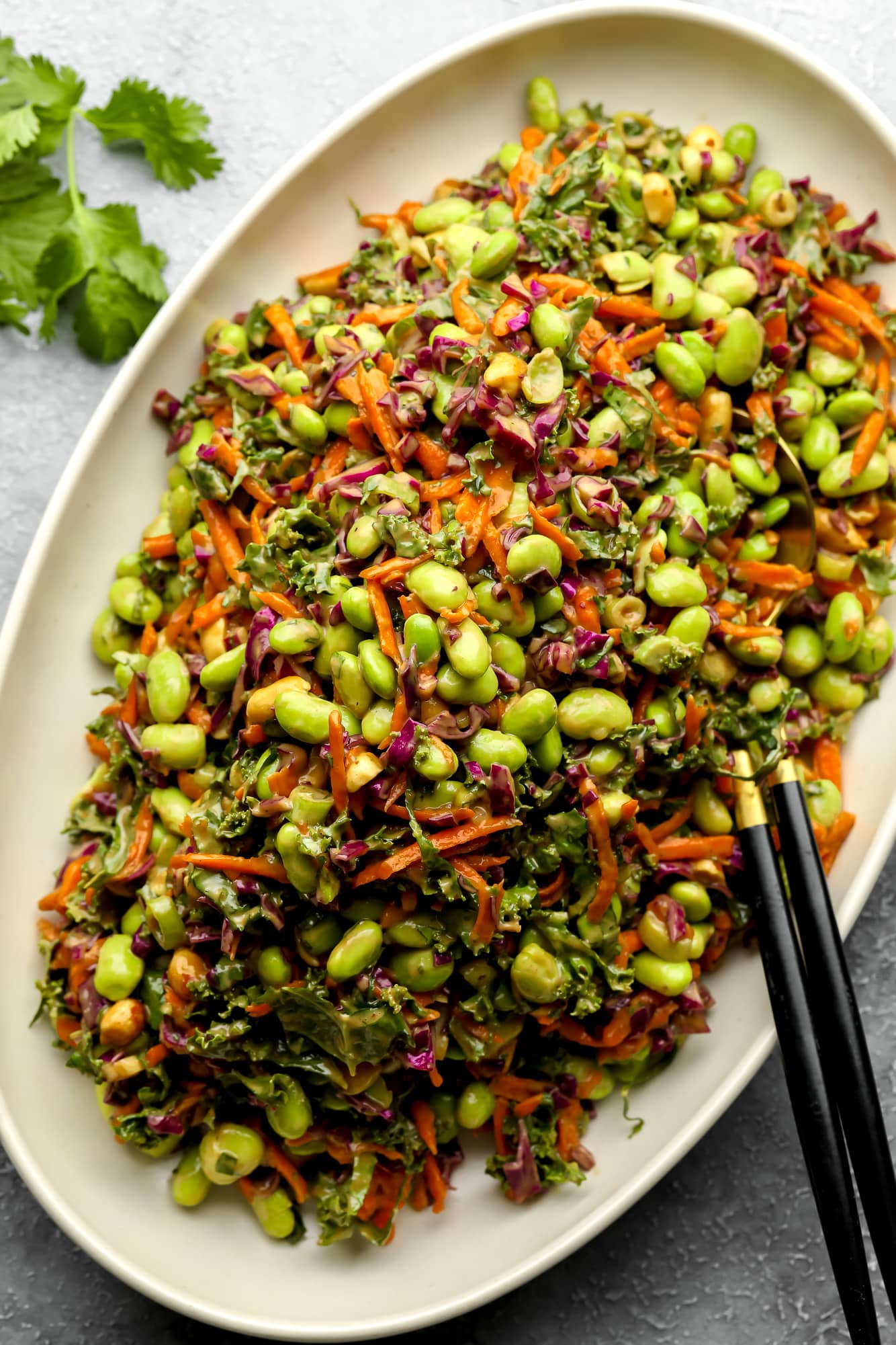 a large batch of Edamame Salad with Peanut Sauce on a white serving platter.