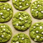 close up on green white chocolate chip matcha cookies on a layer of parchment paper.
