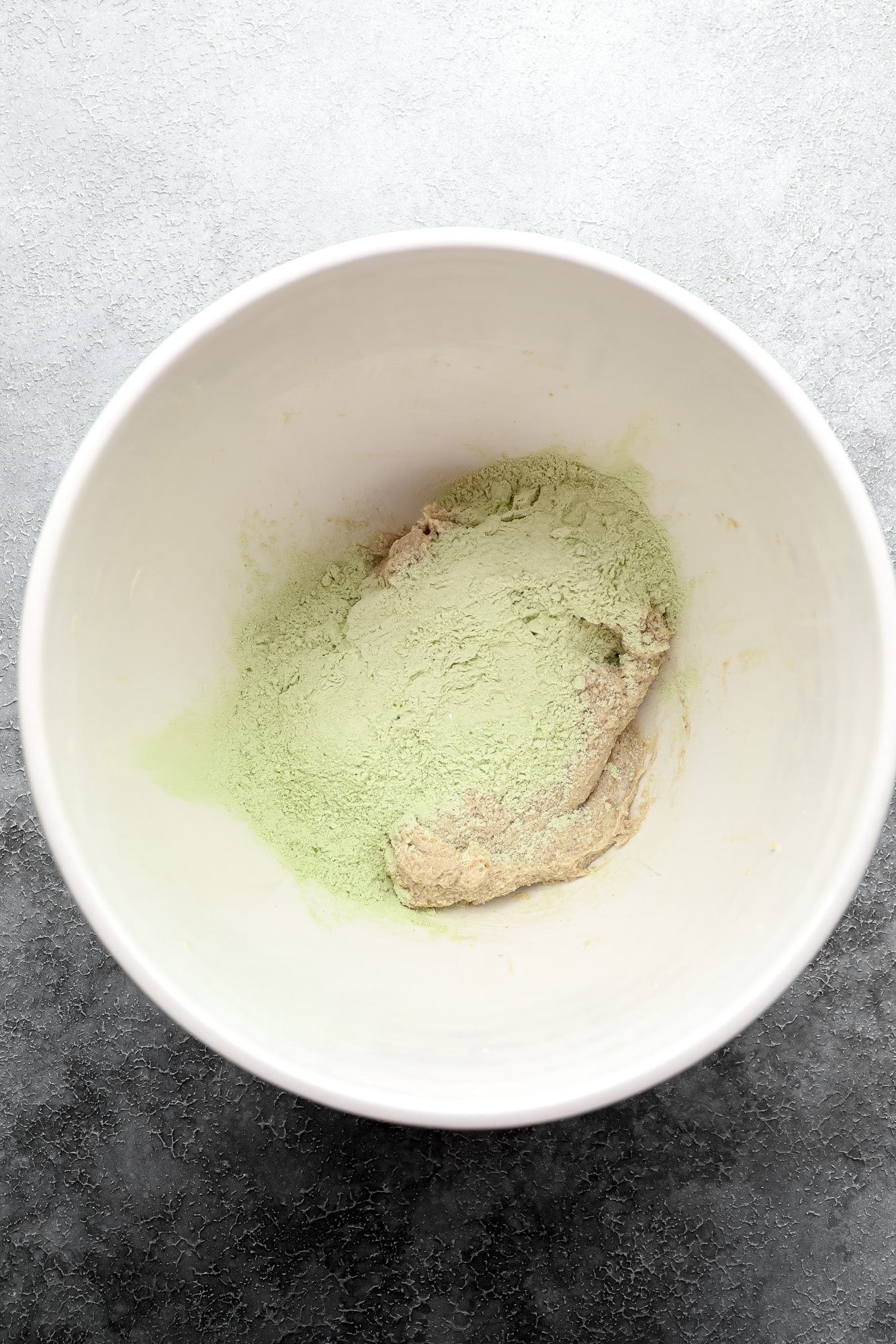 making matcha cookie dough in a large white bowl.
