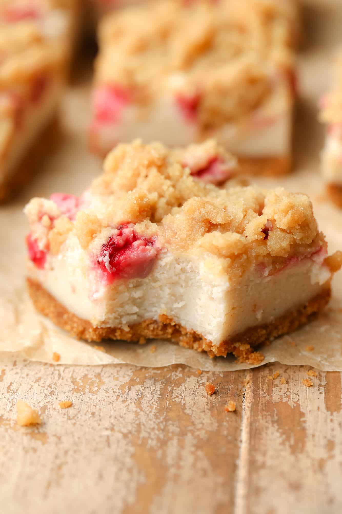 a Vegan Strawberry Cheesecake Crumble Bar with a bite removed.