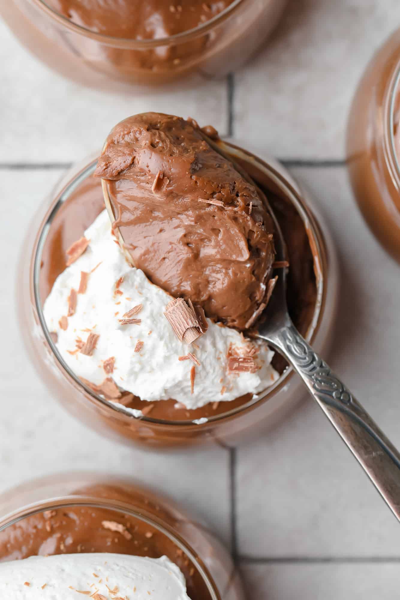 a spoonful of tofu chocolate mousse over top of a glass jar of mousse.
