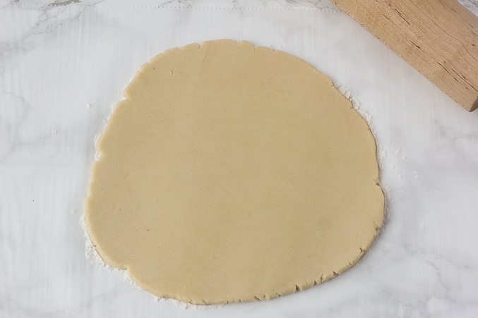 a rolled out circle of vegan sugar cookie dough.