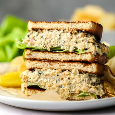 square image of a chickpea tuna salad sandwich with grey background