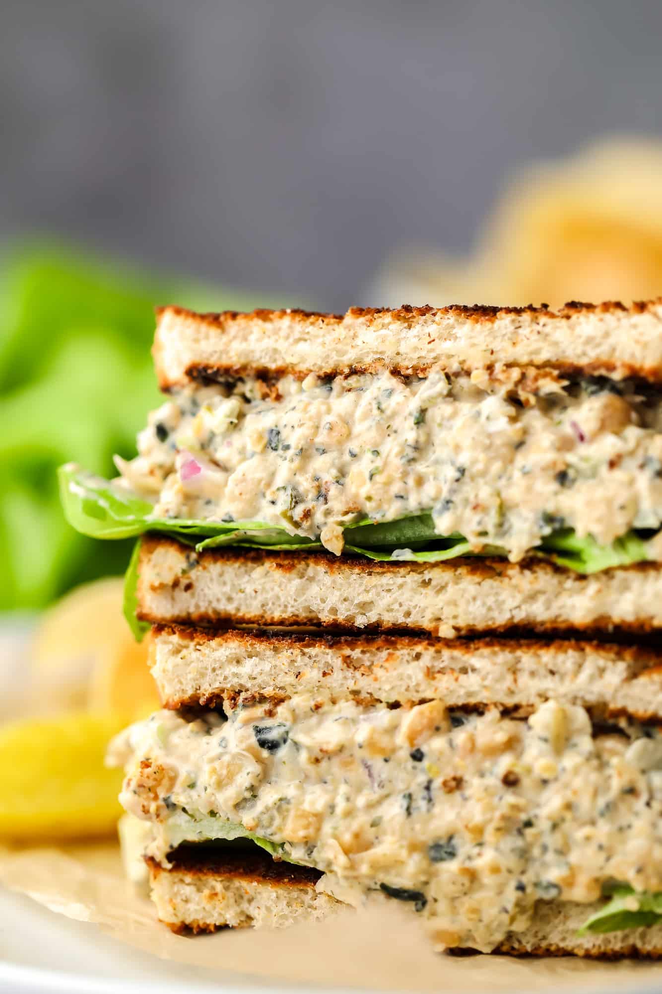 close up of chickpea tuna salad in a sandwich with grey background