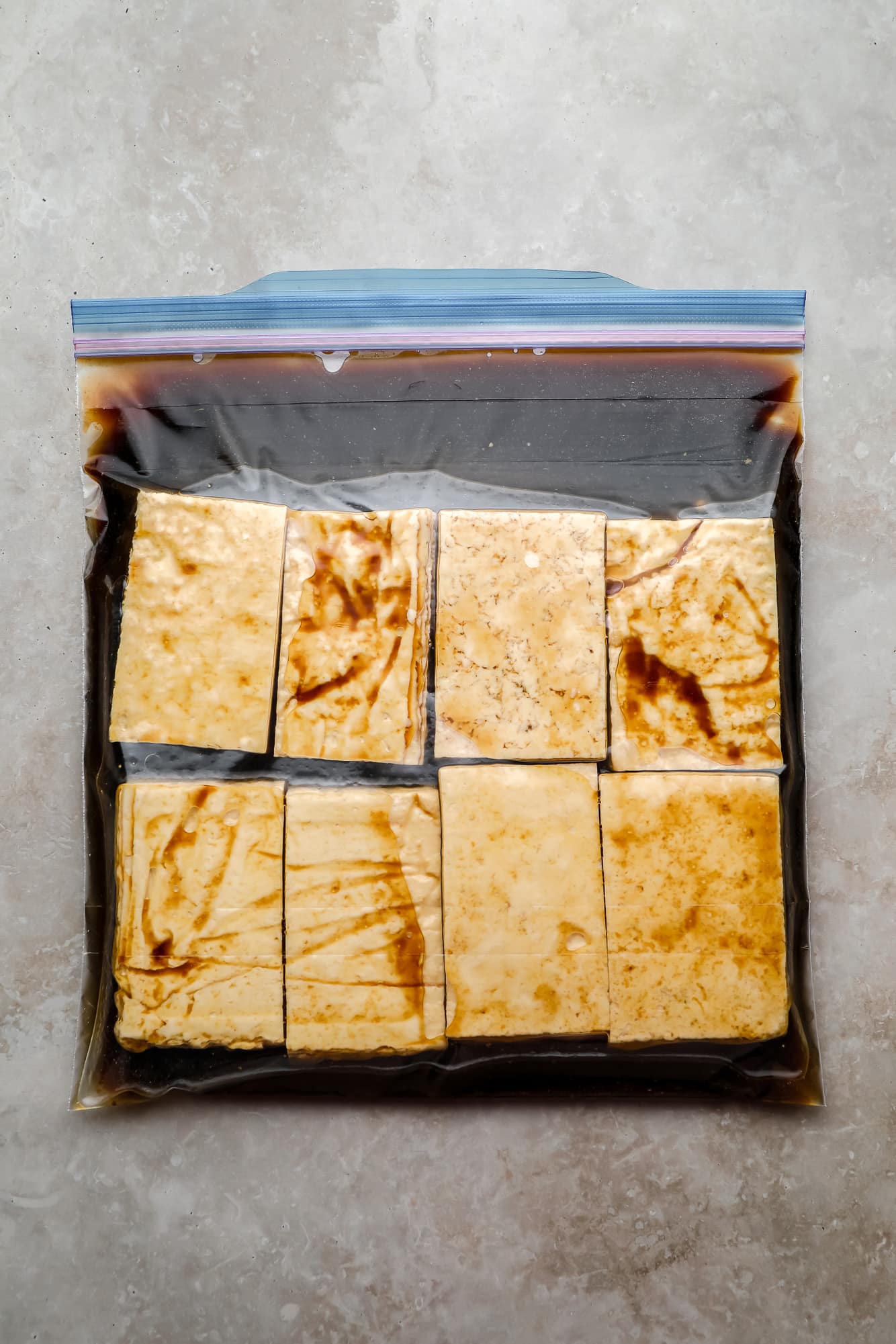 rectangular tofu pieces and a marinade in a large ziplock bag.