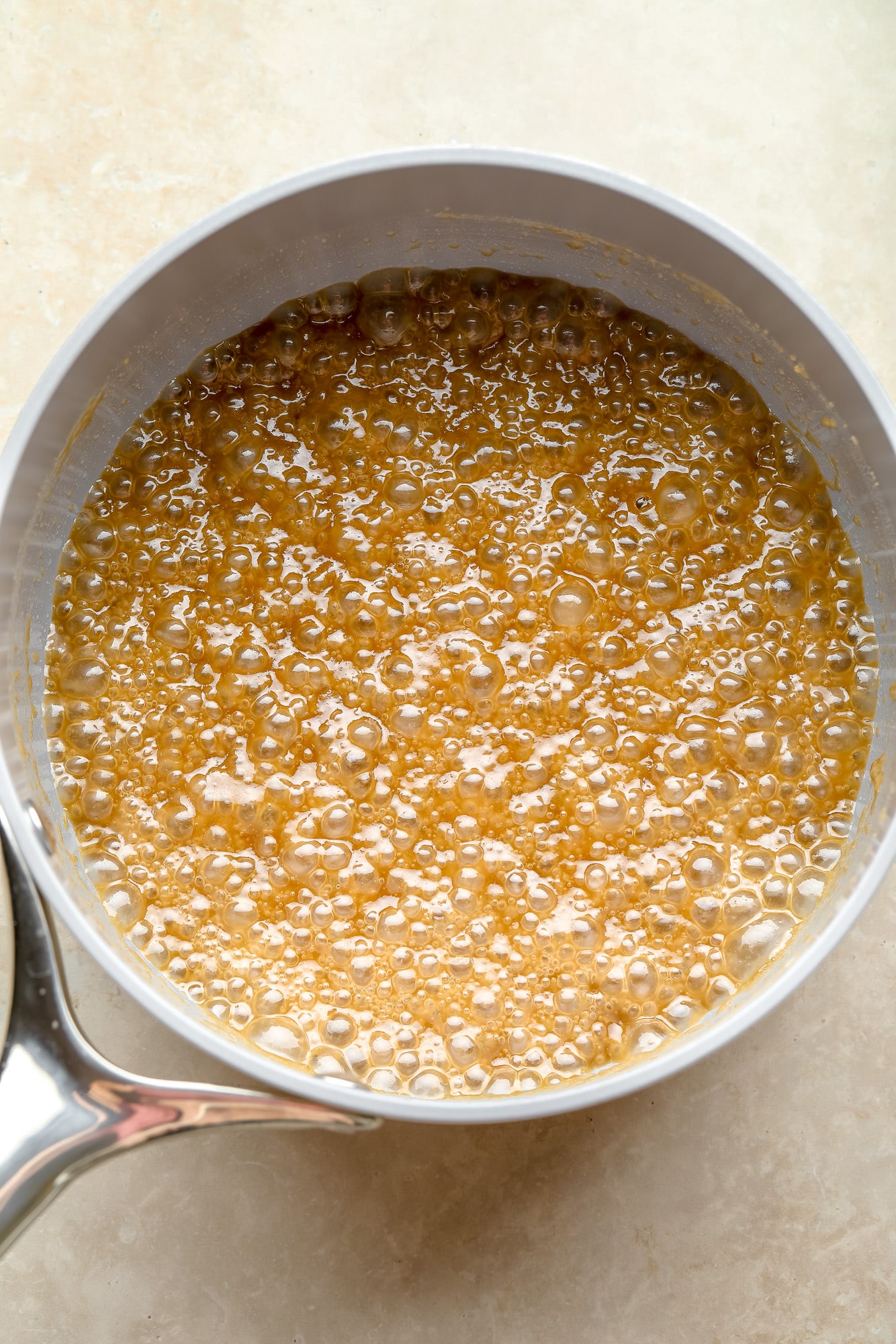 vegan caramel simmering in a grey pot.