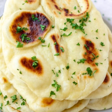 square image of stacks of vegan naan with parsley