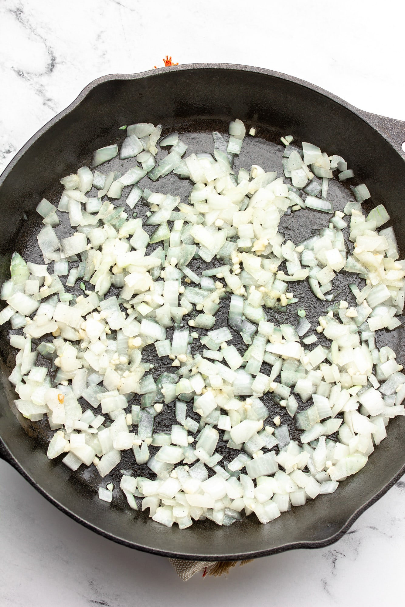 cooking diced onions in a black skillet.