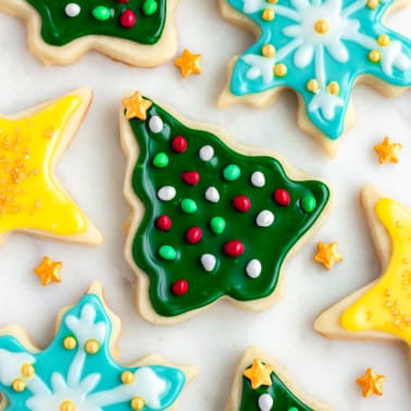 square image of laid flat christmas cookies decorated with sprinkles and icing