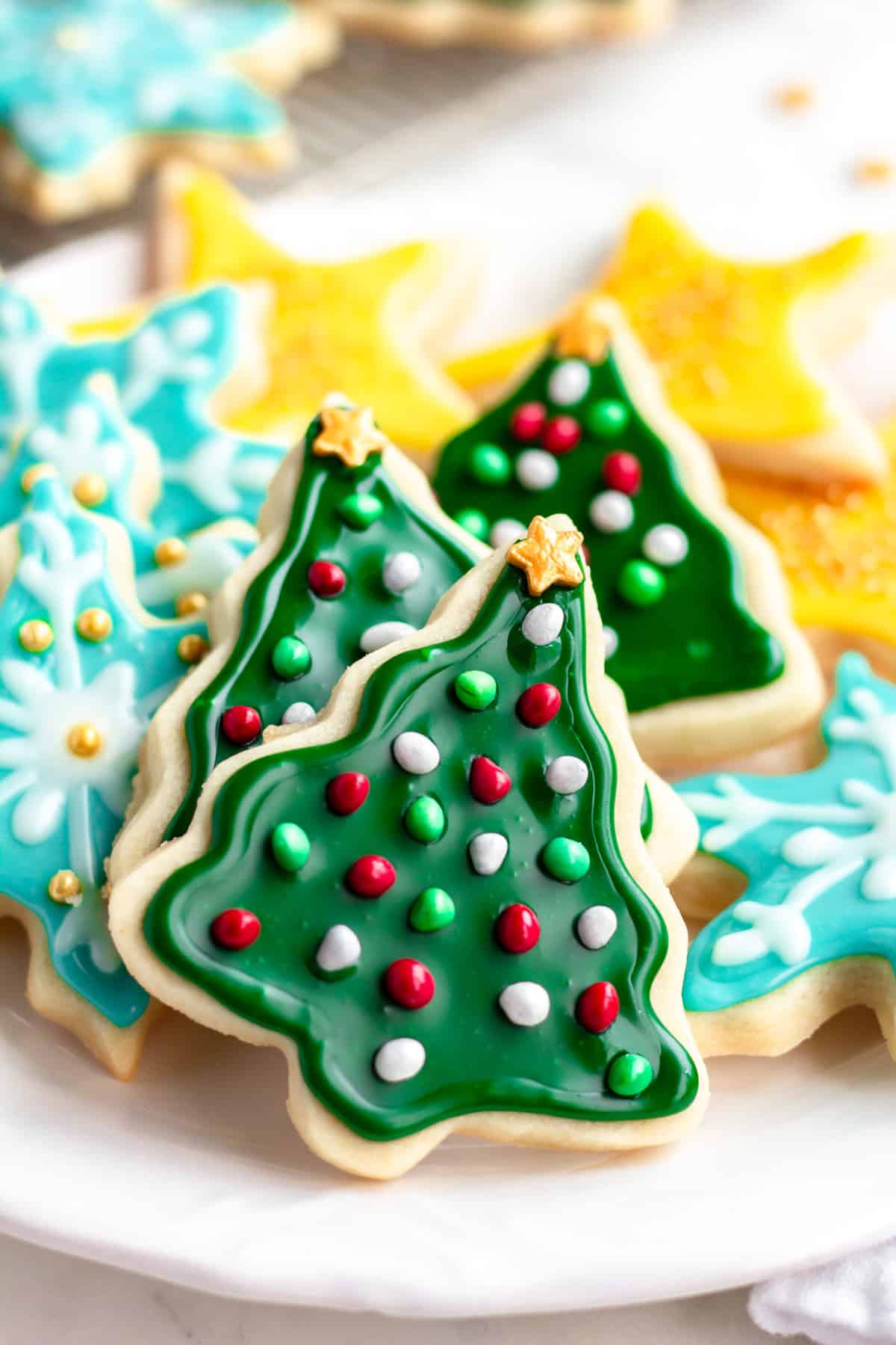 christmas cookies on a plate, showing trees, stars and snowflakes