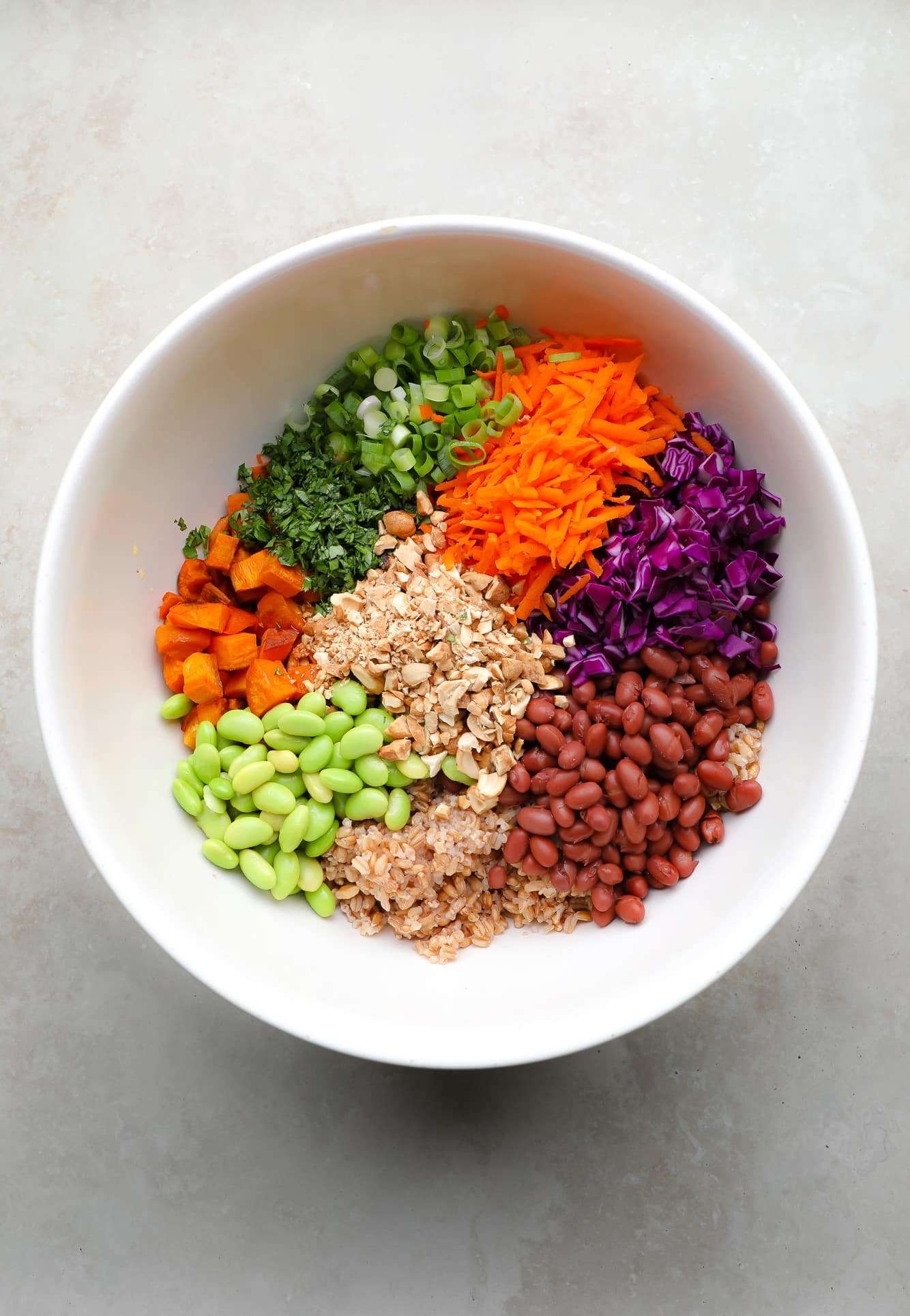 ingredients for farro salad together in a large white bowl.