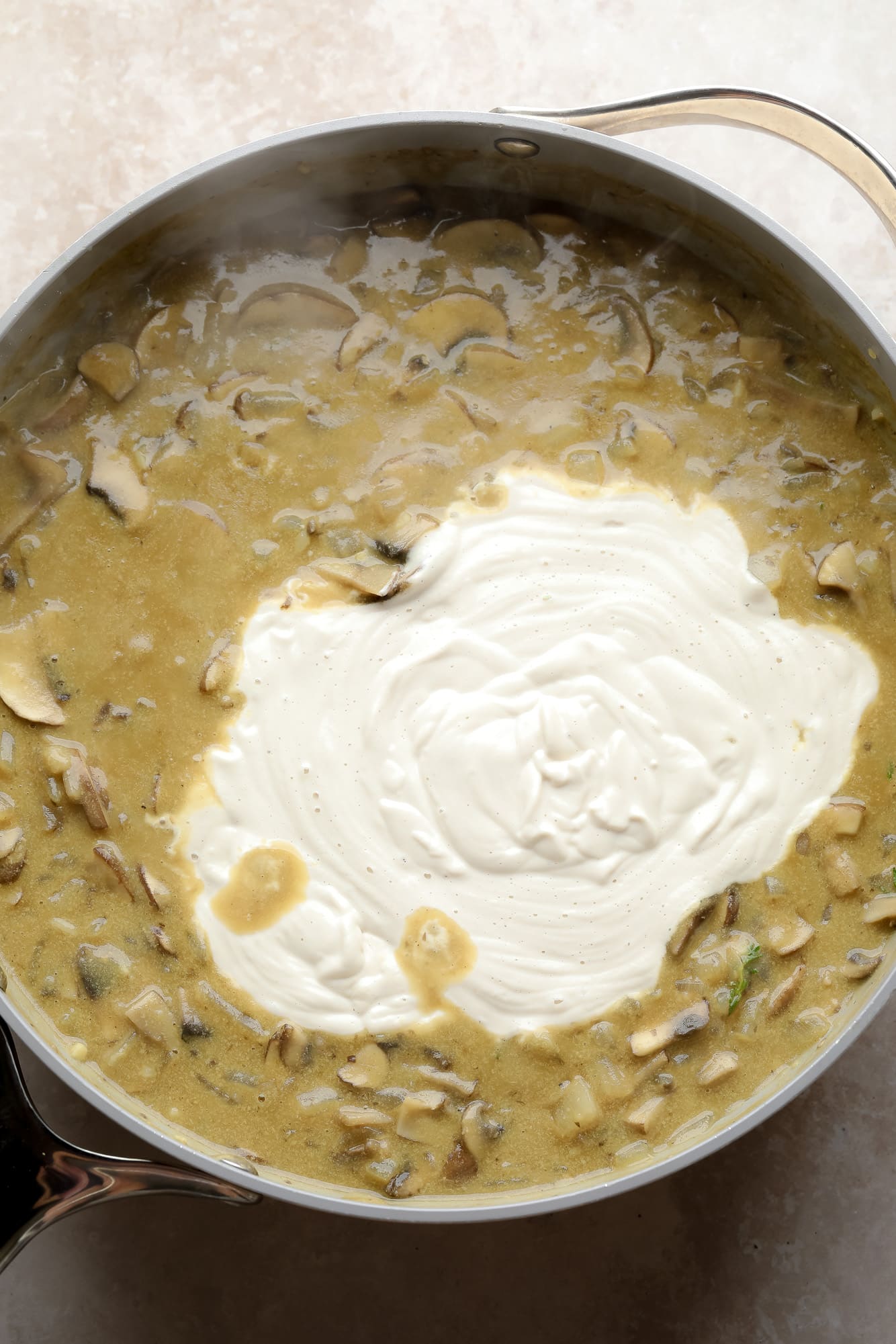 cooking the mushroom gravy and cashew cream for mushroom stroganoff in a large grey pot.