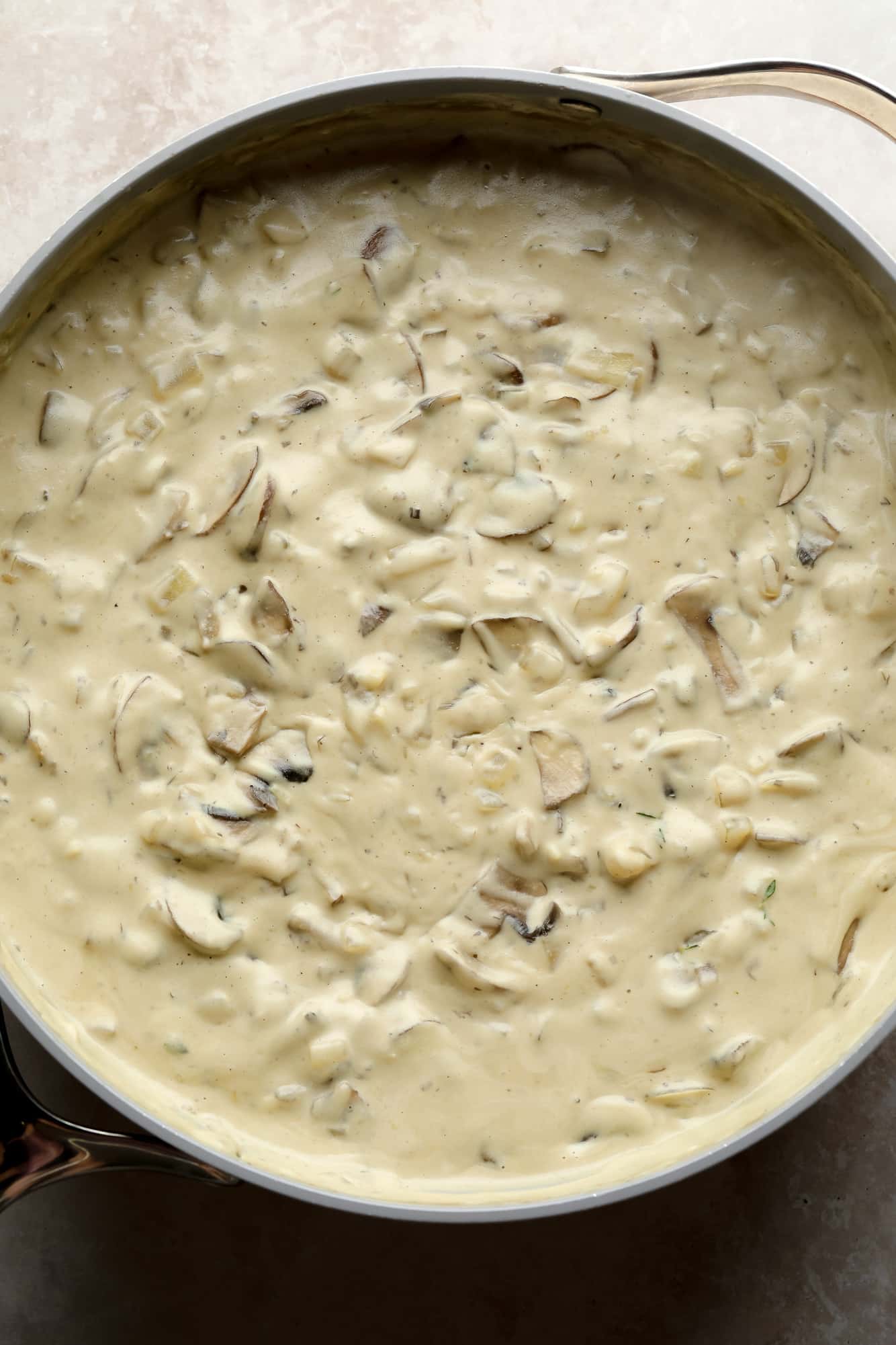 the creamy mushroom gravy for mushroom stroganoff in a large grey pot.