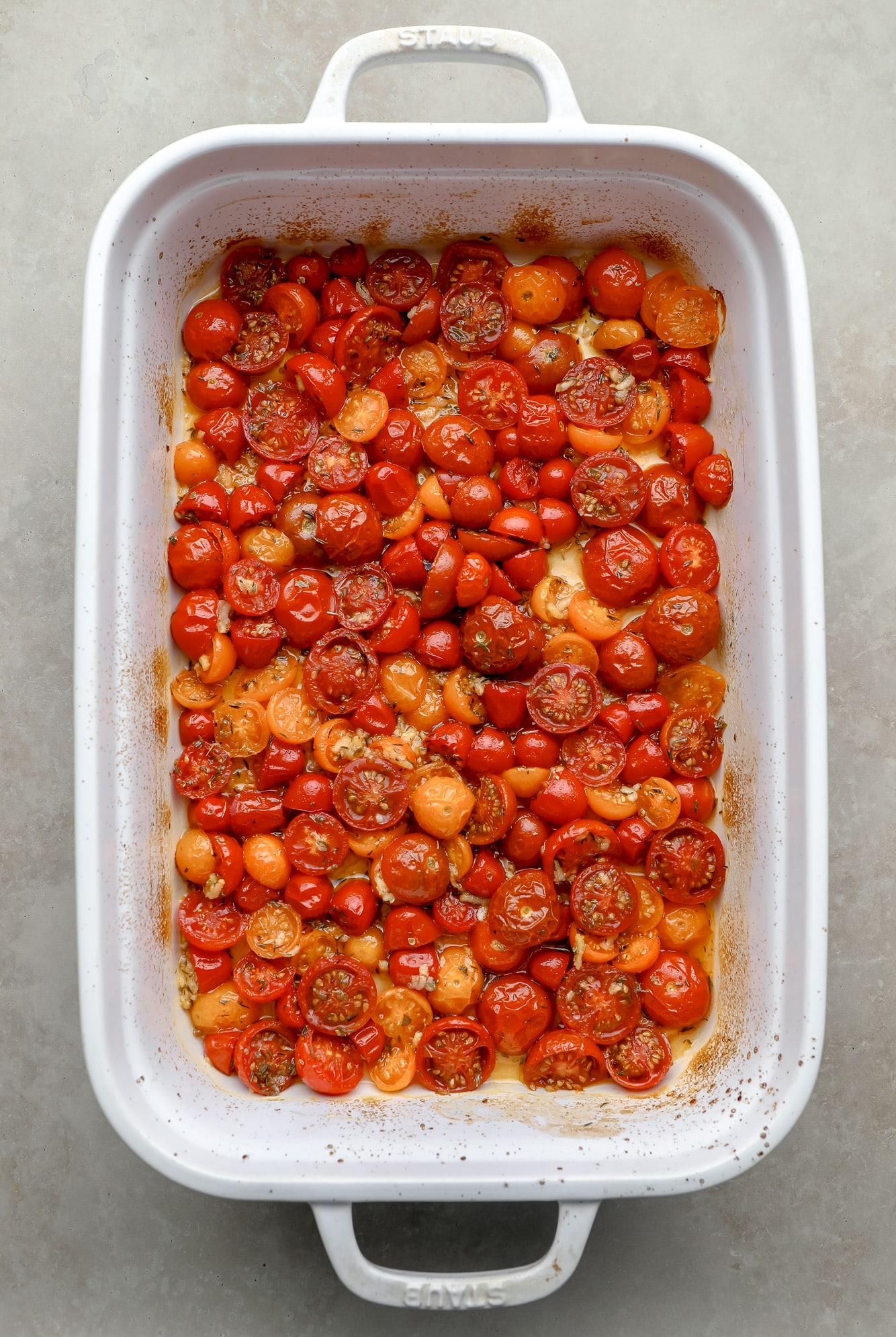 roasted cherry tomatoes in a large white baking dish.