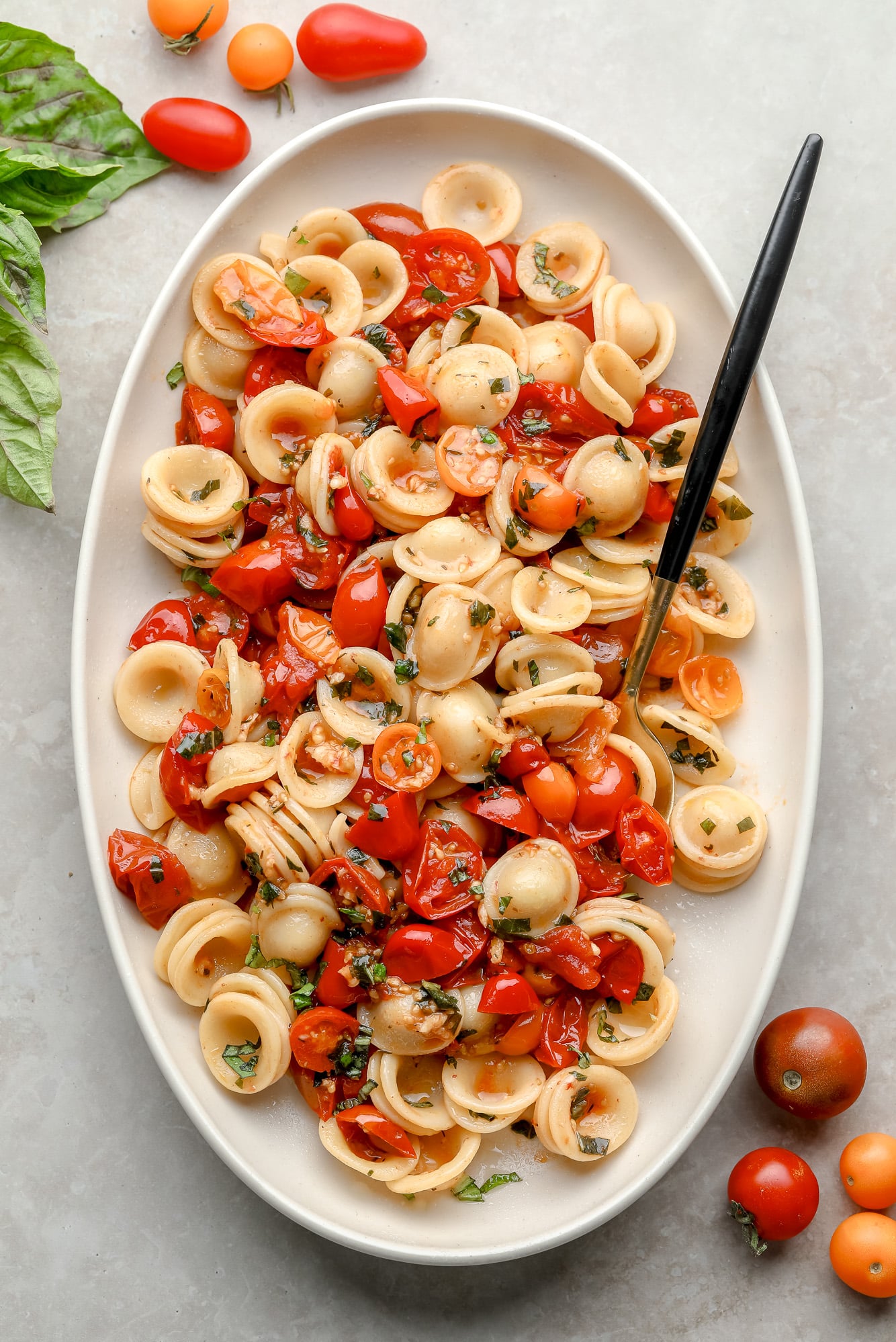 Roasted Tomato Pasta in a white serving dish with a spoon.