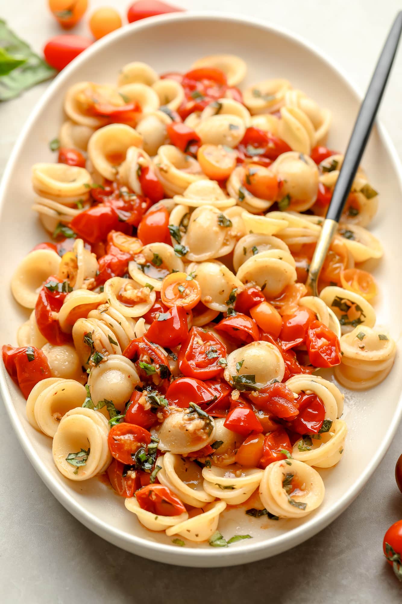 Roasted Tomato Pasta in a white serving dish with a spoon.