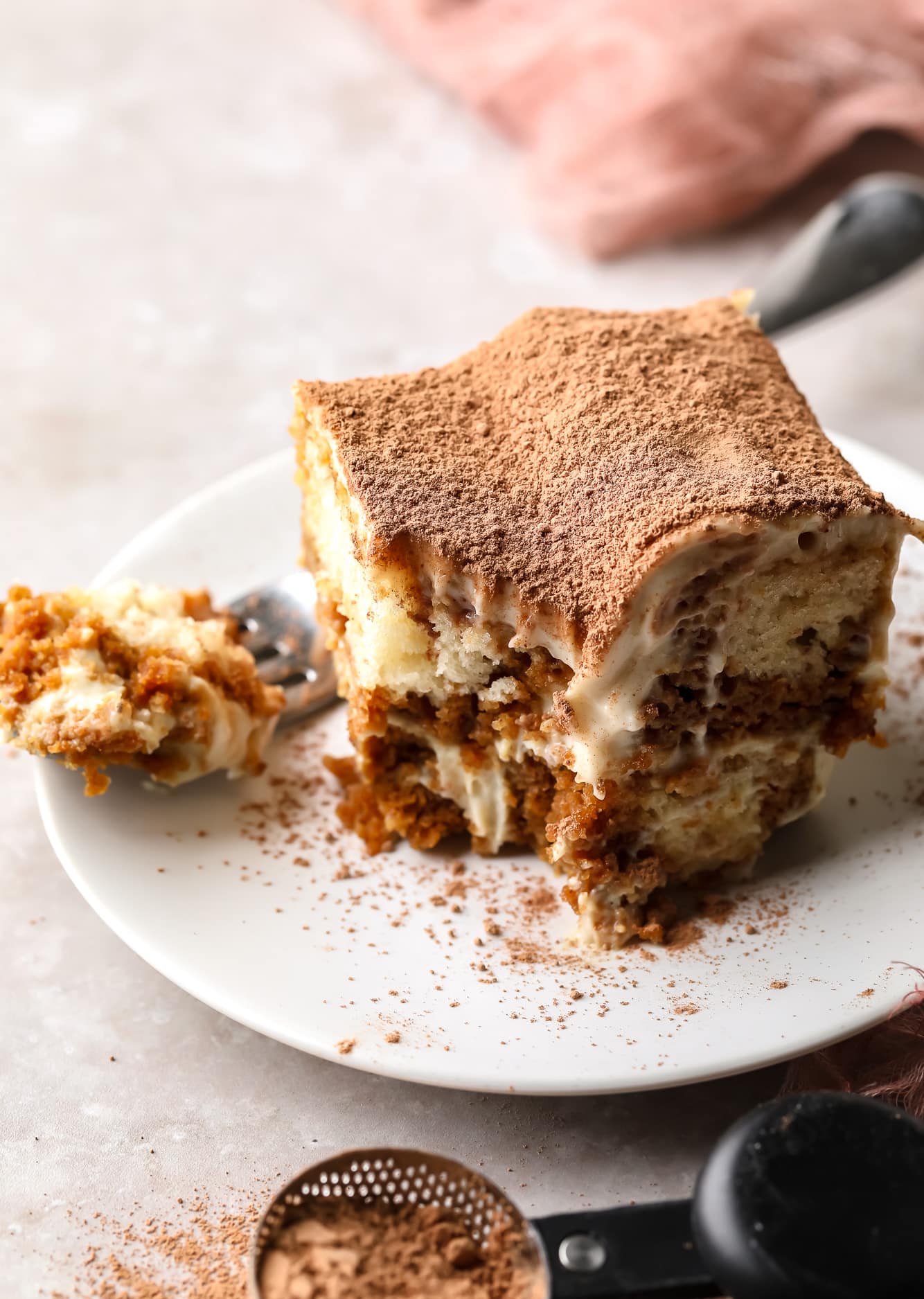 a slice of vegan tiramisu on a white plate.