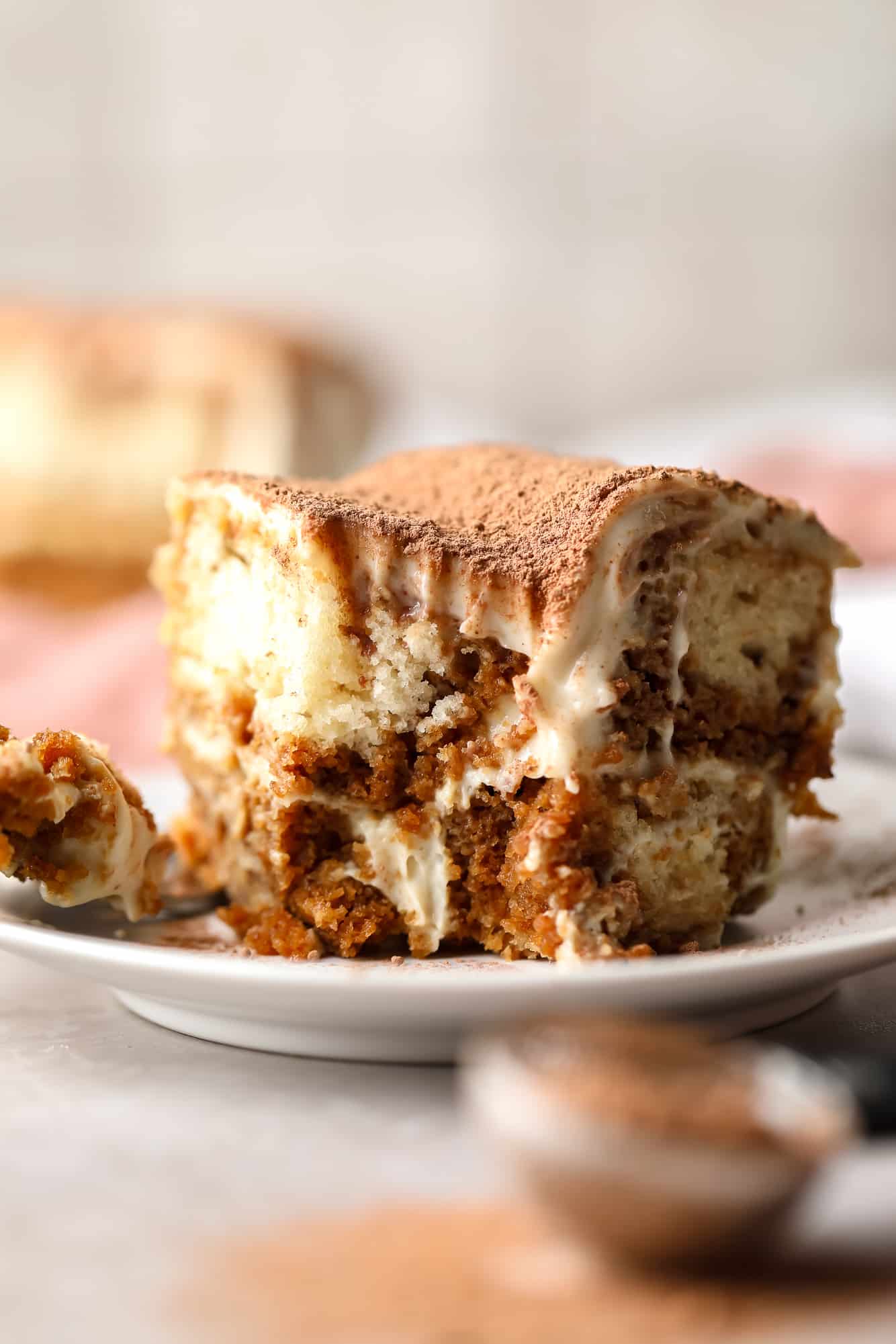 close up on a slice of vegan tiramisu with a bite missing.