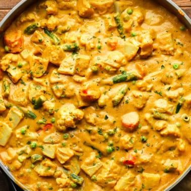 close up on a large pot of golden vegetable korma.