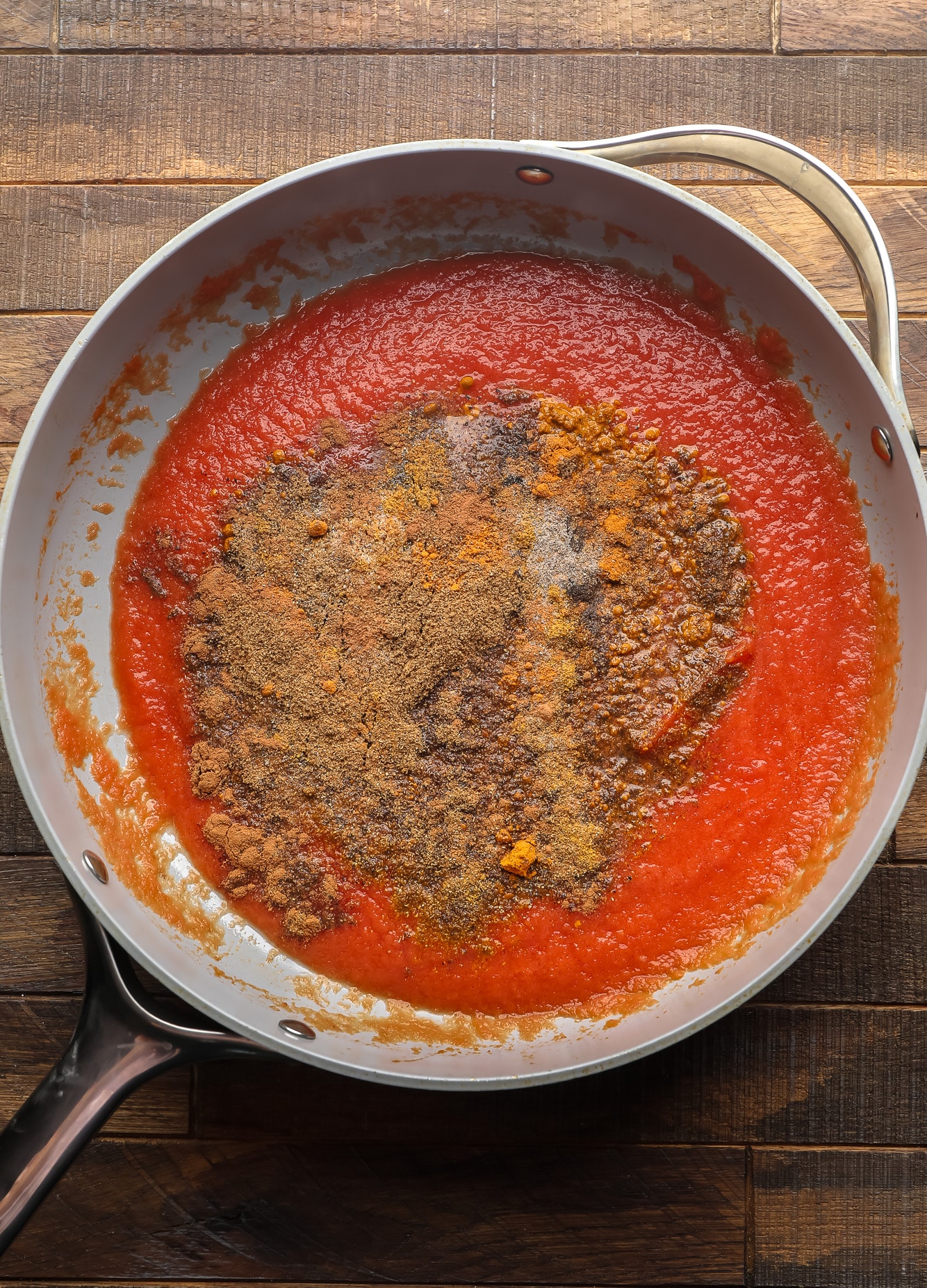 Indian spices and tomato sauce in a large skillet.