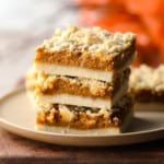 close up on 3 vegan pumpkin crumble bars stacked on top of each other.