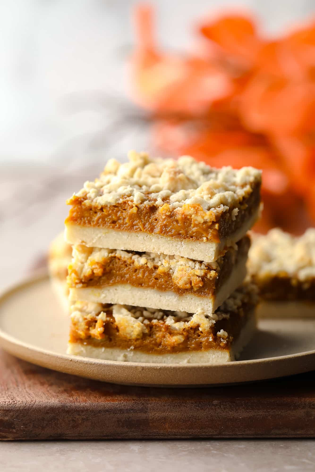 3 vegan pumpkin crumble bars stacked on top of each other.