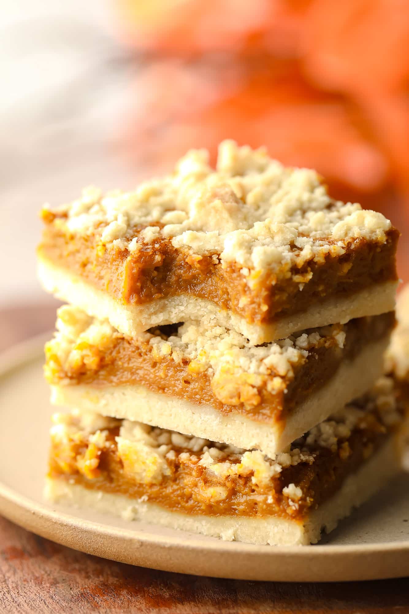 3 vegan pumpkin crumble bars stacked on top of each other.