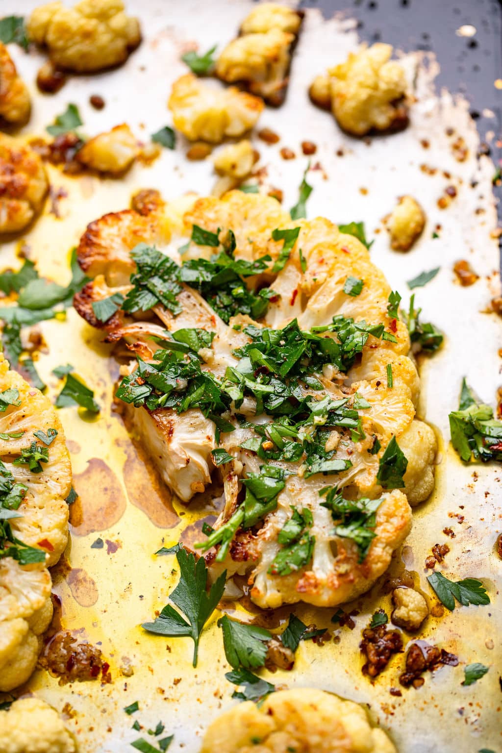 roasted cauliflower on a baking sheet with herbs