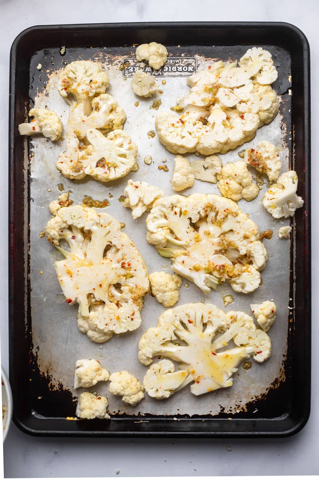 5 cauliflower steaks on a baking sheet ready to bake