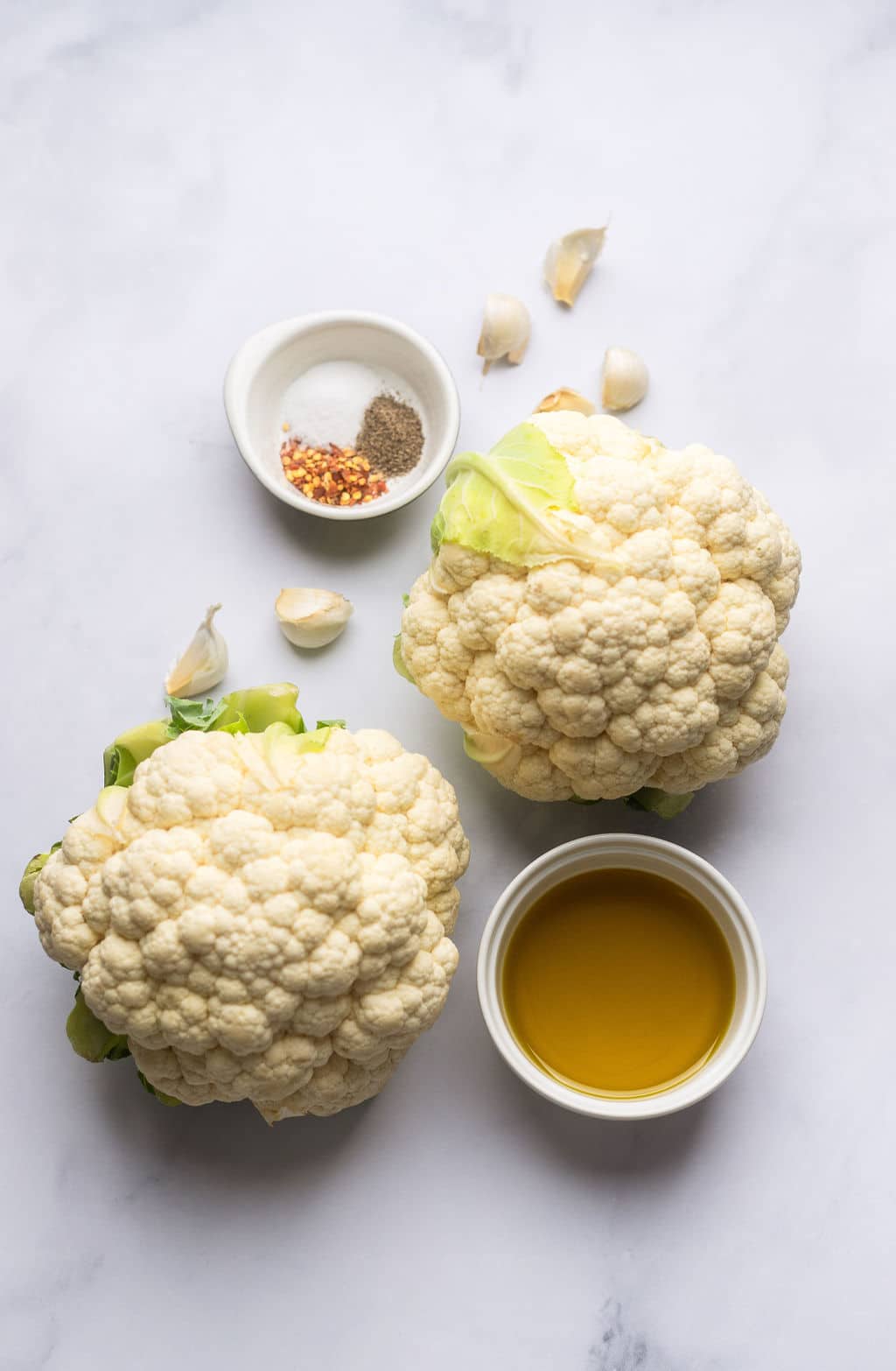 whole cauliflowers, spices, garlic and olive oil