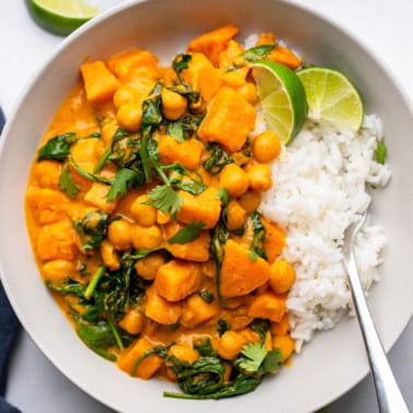 Sweet Potato Curry with Chickpeas served with white rice in a white bowl.