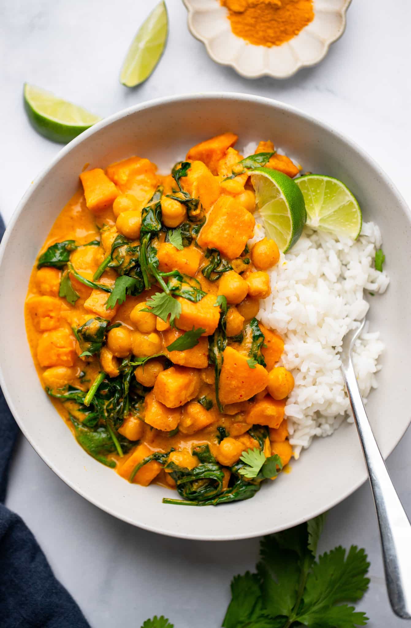 Sweet Potato Curry with Chickpeas served with white rice in a white bowl.