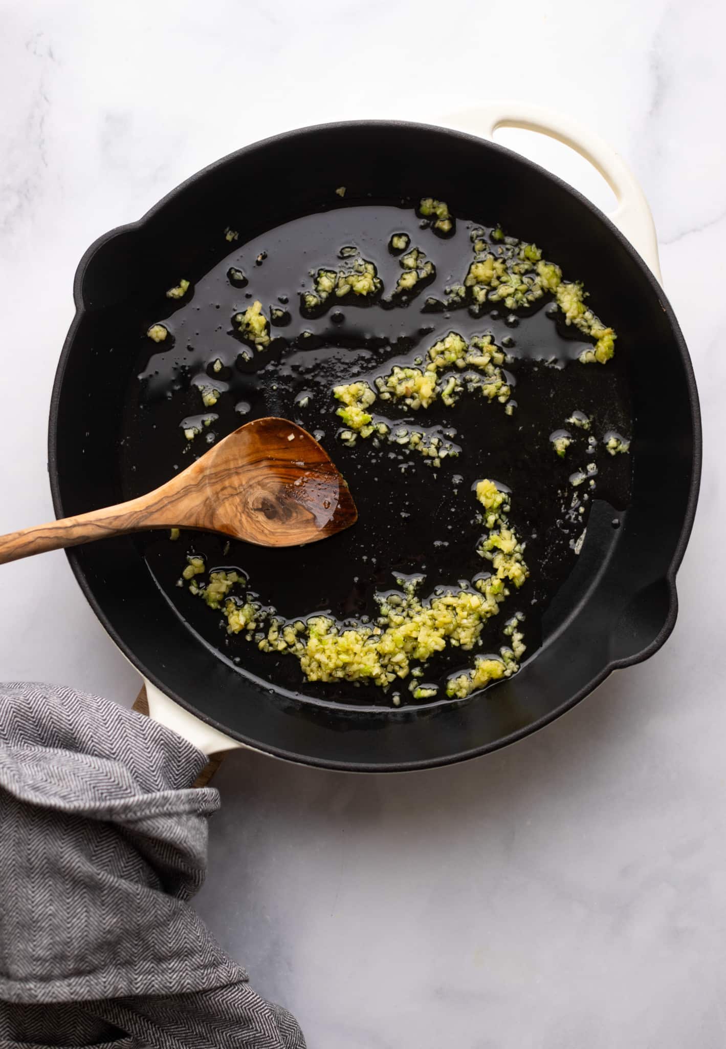 cooking garlic in a black skillet.