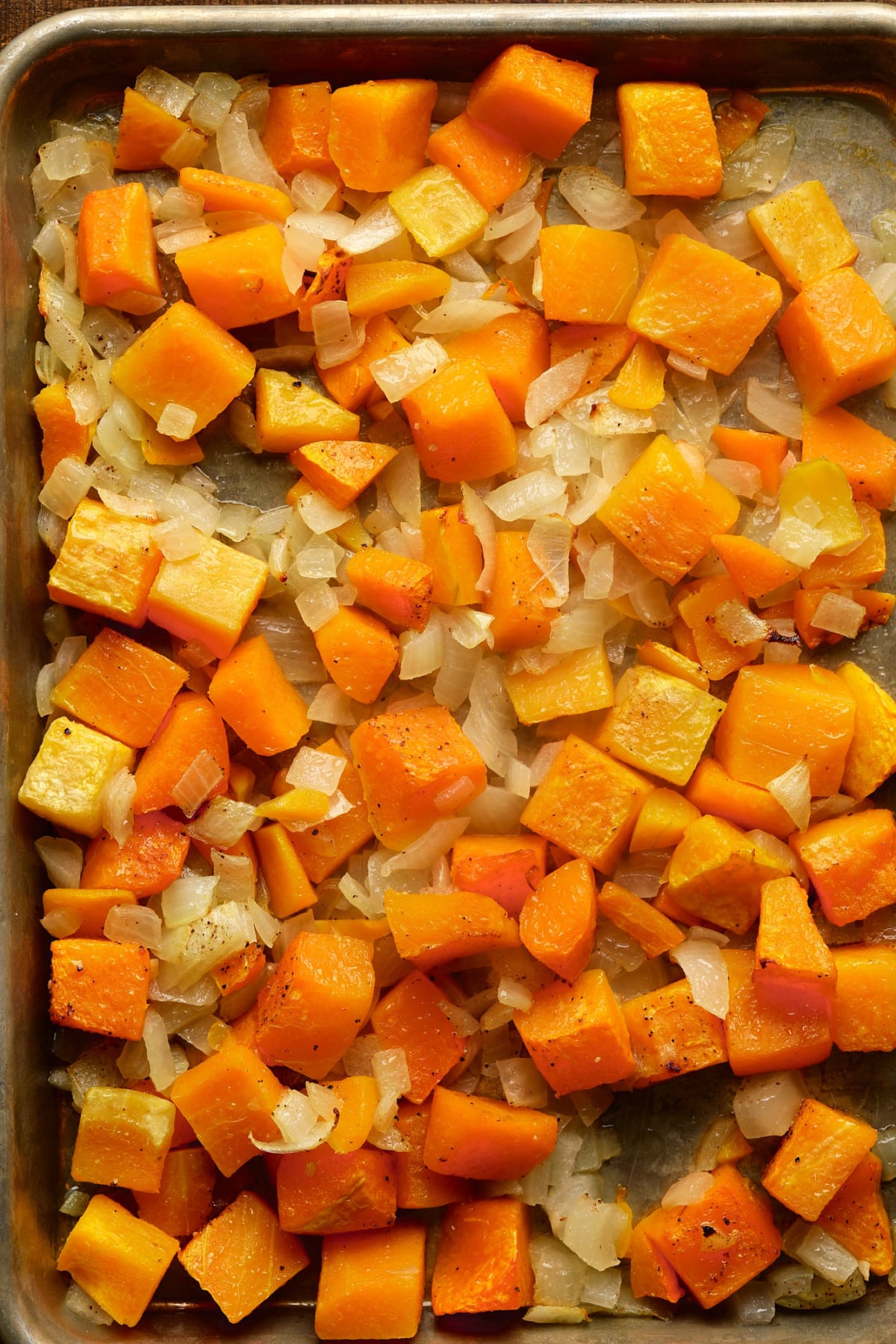 roasted squash and onions on a baking sheet