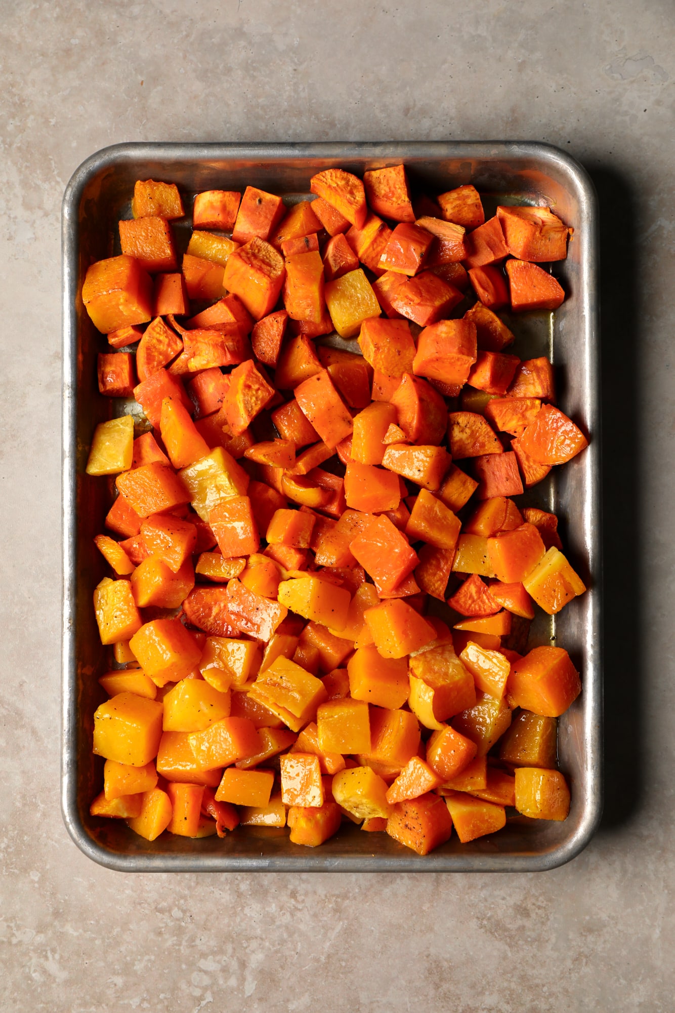 roasted cubes of butternut squash and sweet potatoes on a sheet pan.