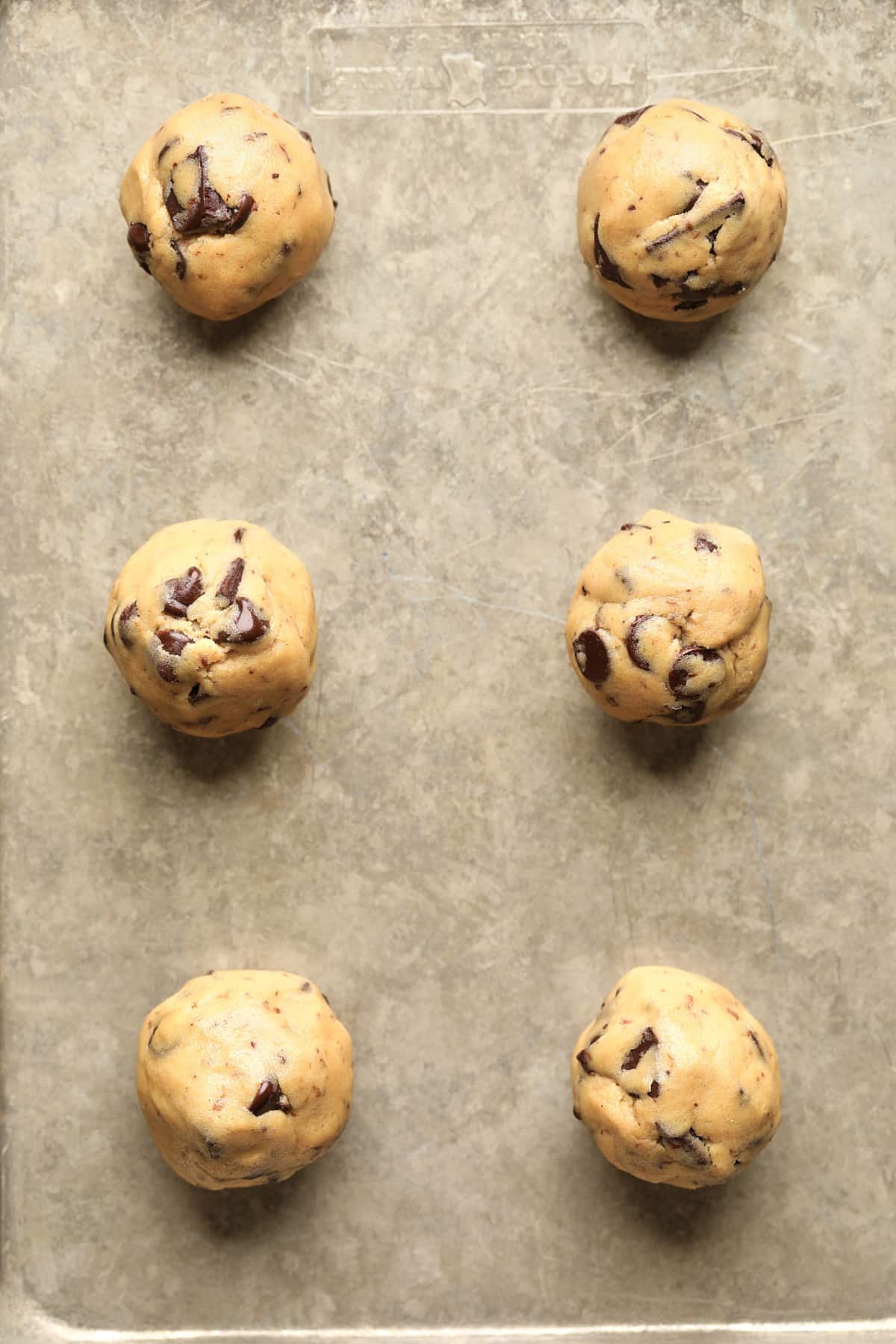 cookie dough balls on a baking sheet before baking