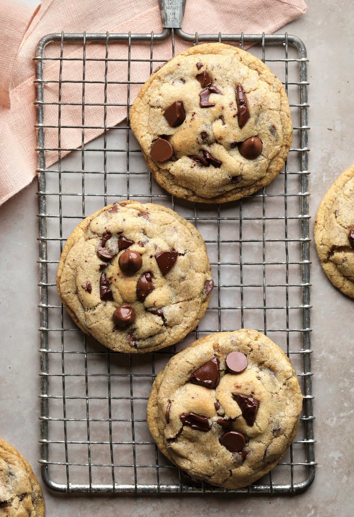 a few cookies on a cooling rack with pink towel and greyish background