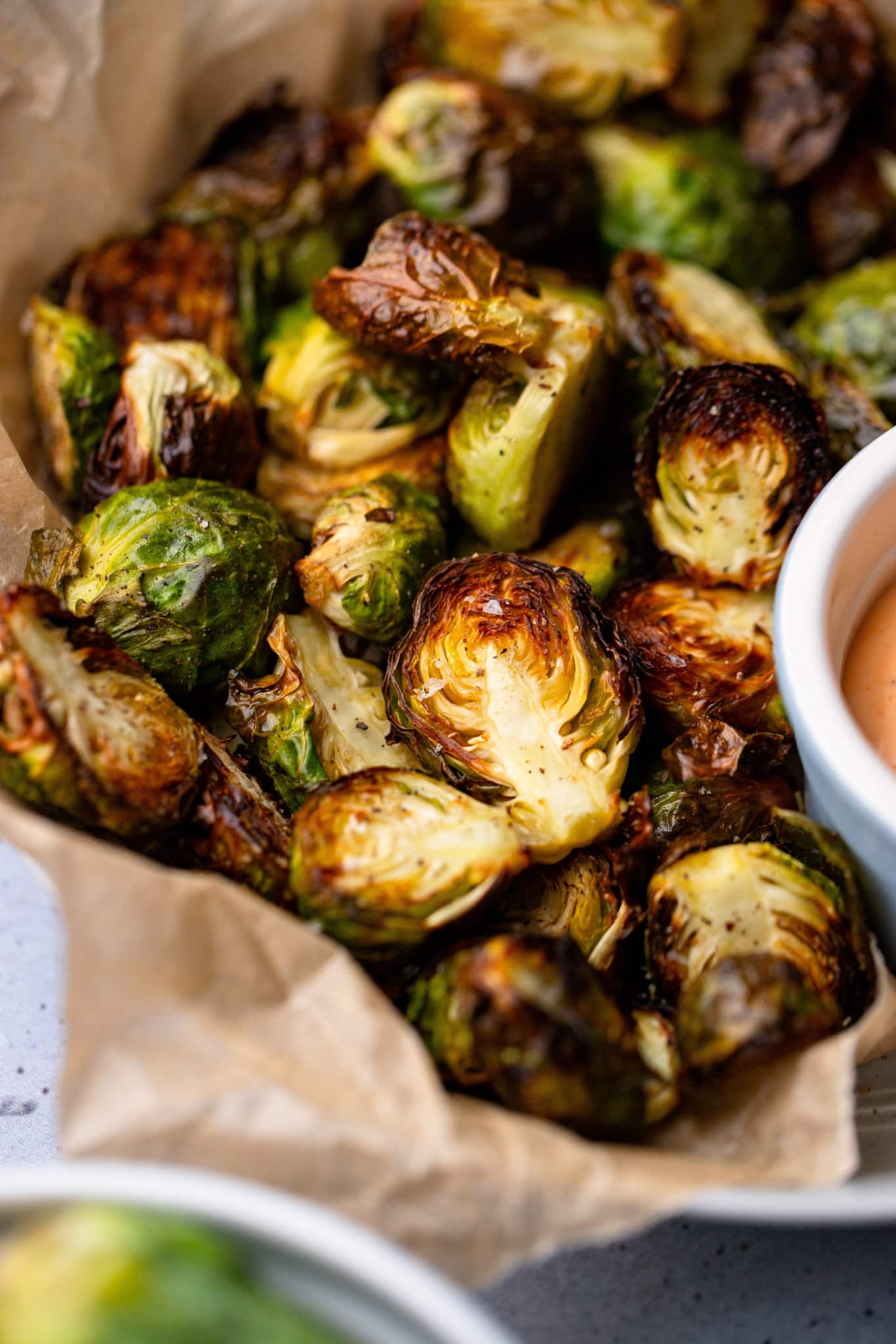 close up on cooked brussels sprouts in a serving bowl.