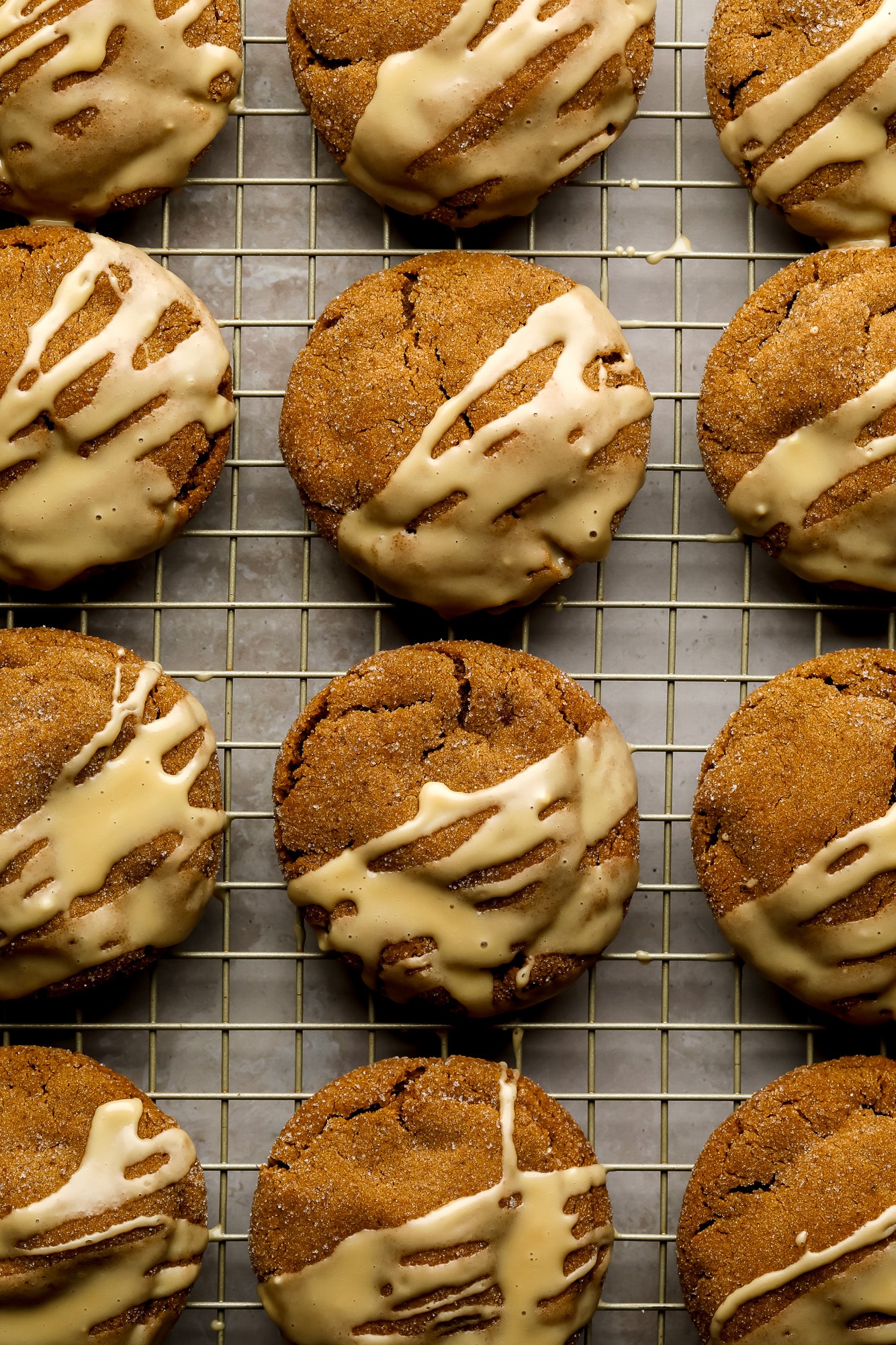 Gingerbread Latte Cookies drizzled with a white espresso glaze on a wire rack.