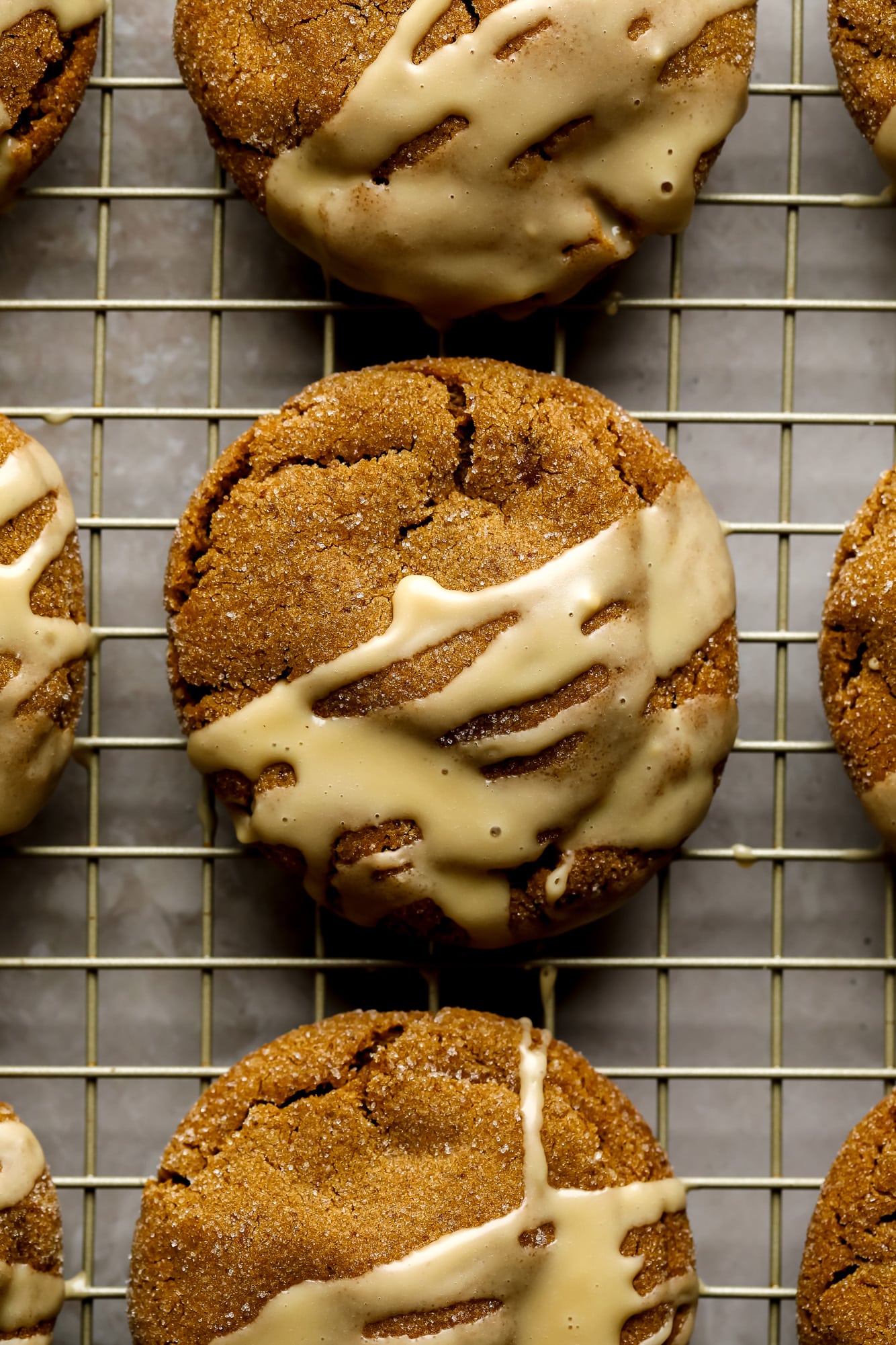 Gingerbread Latte Cookies drizzled with a white espresso glaze on a wire rack.