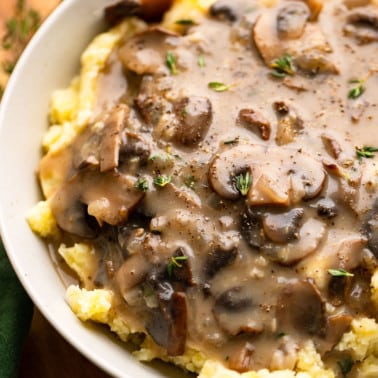 close up on mushroom gravy serrved on top of mashed potatoes.