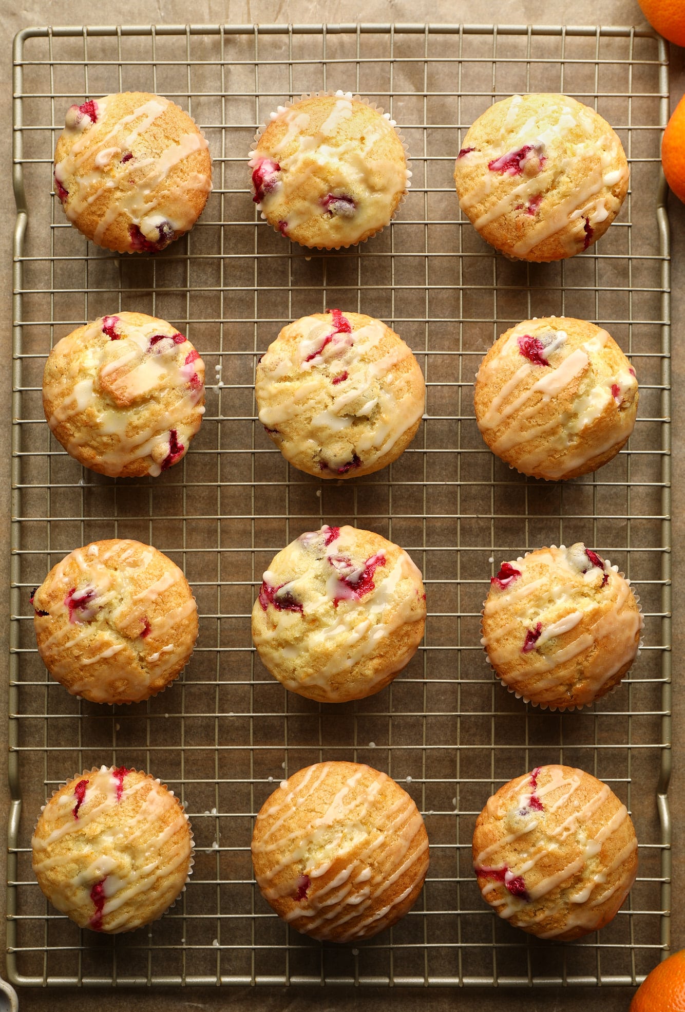 glazed cranberry orange muffins on a wire rack.