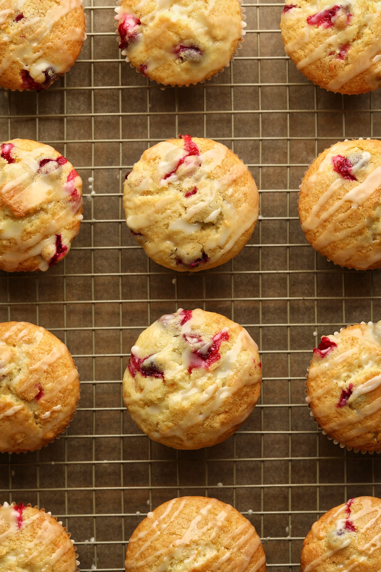 glazed cranberry orange muffins on a wire rack.