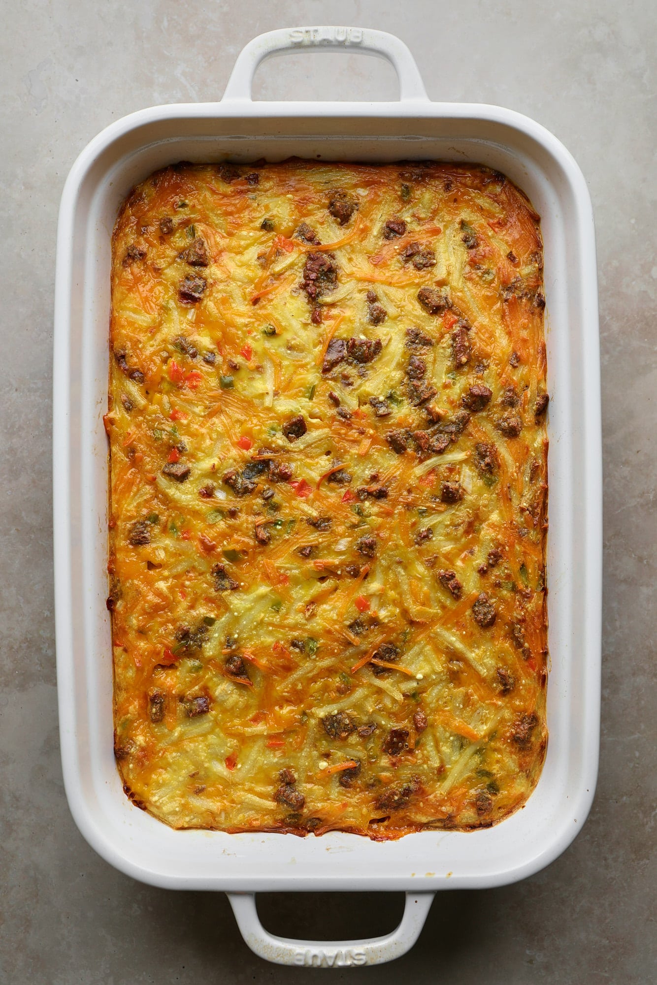 A baked vegan breakfast casserole in a white baking dish.