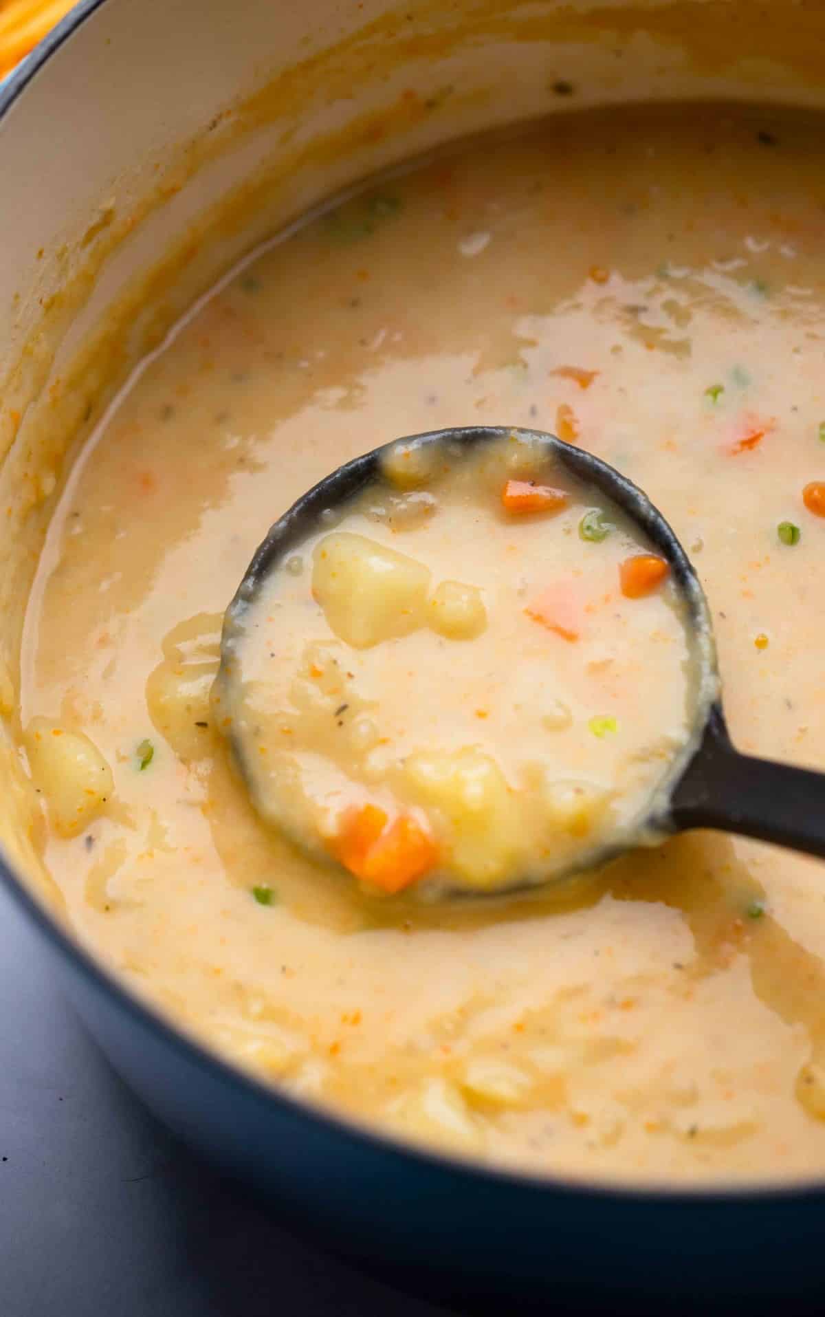 ladle with creamy potato soup in a pot