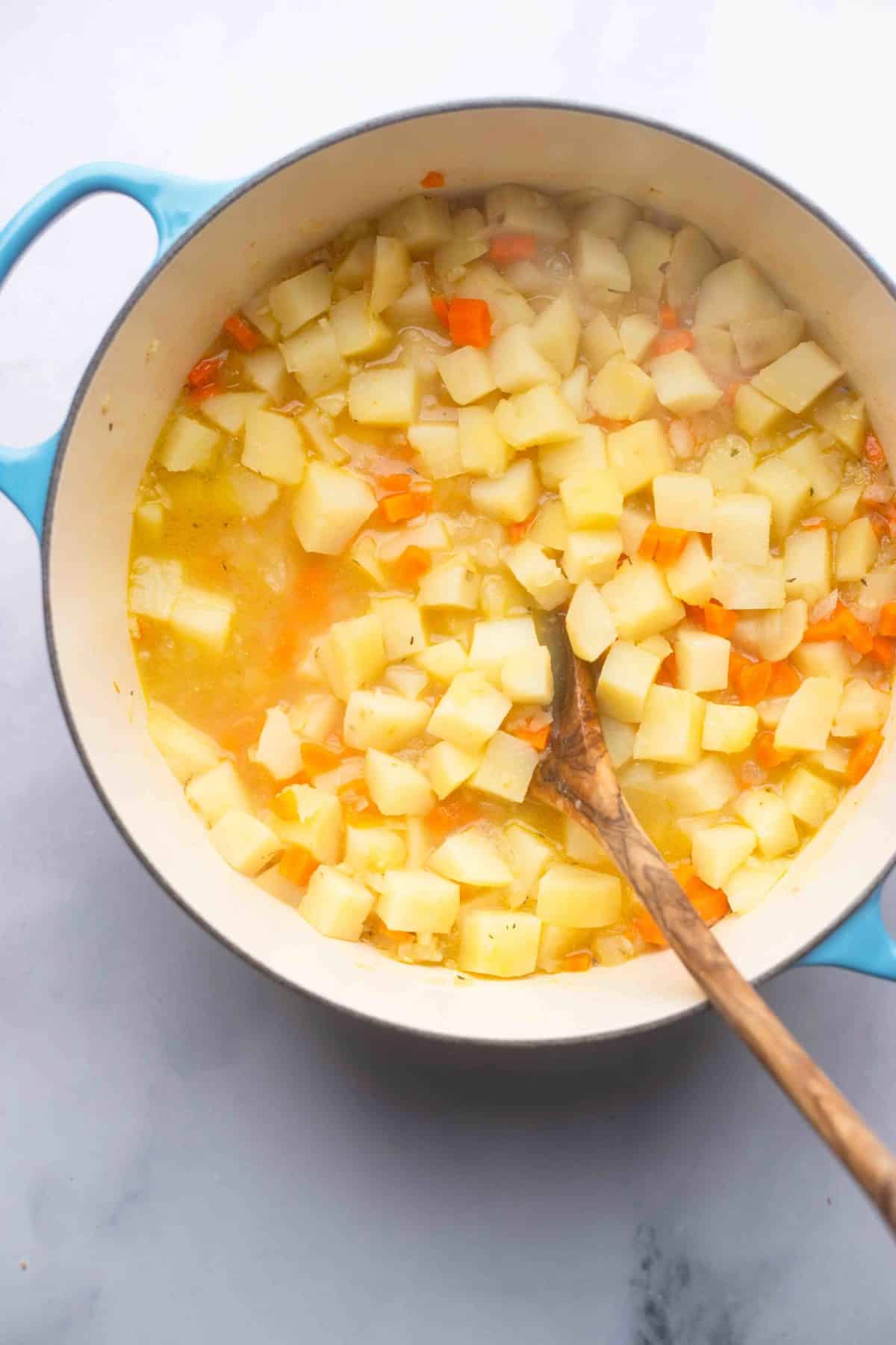 cooked potatoes and carrots in broth