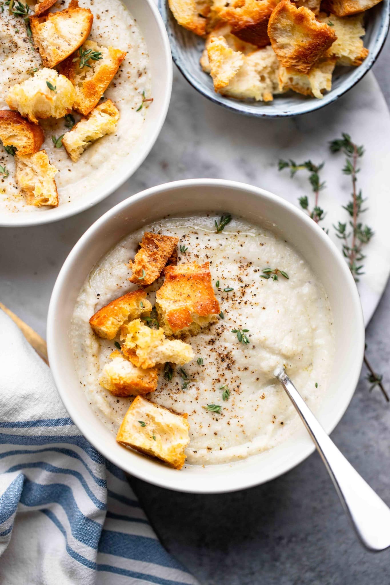 a bowl of vegan cauliflower soup topped with croutons.