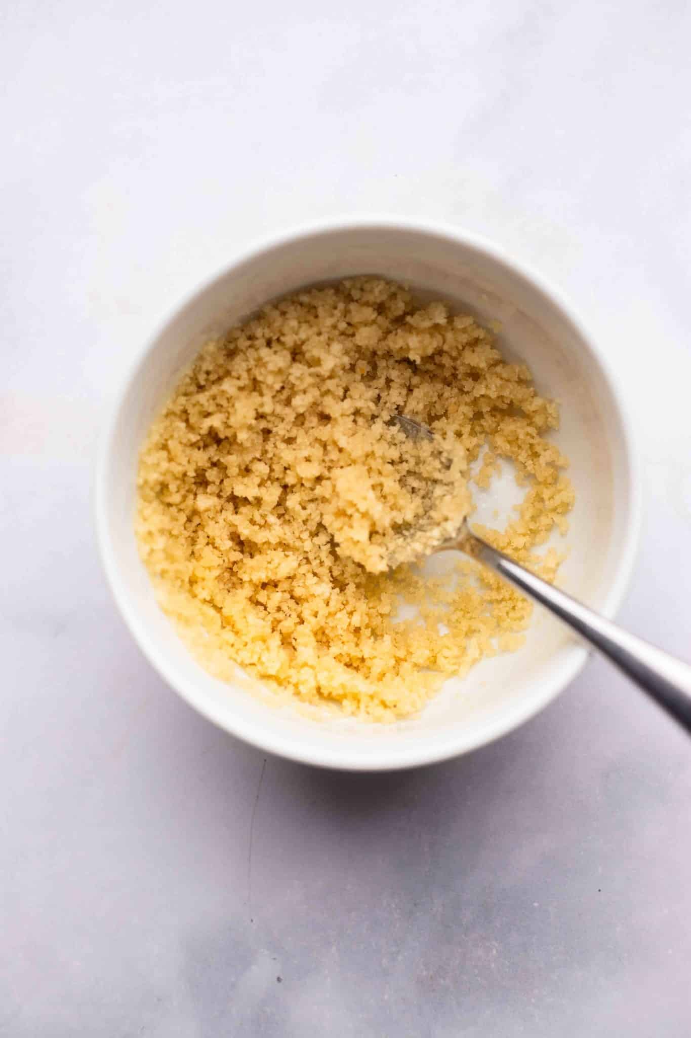 breadcrumbs and butter stirred together in a white bowl.